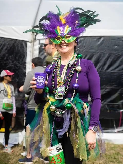 Runner in a purple feather mask holding a Dash cup